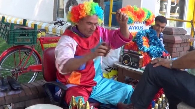 Palyaço kostümüyle hem ayakkabı boyuyor hem insanları eğlendiriyor